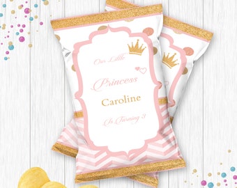 May include: Pink and gold chip bags with a chevron pattern and gold glitter. The bags have a white label with the text "Our Little Princess Caroline is Turning 3".