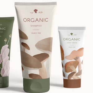 Op de afbeelding: Twee witte tubes met biologische beautyproducten met een paddenstoelontwerp. De grotere tube is gelabeld "Organic Shampoo" en de kleinere tube is gelabeld "Organic Hand Cream". Beide tubes zijn dierproefvrij.
