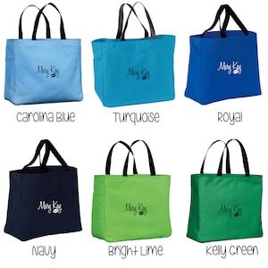 May include: Six tote bags in different colors, including turquoise, royal blue, kelly green, navy, bright lime, and carolina blue. Each bag has black handles and a white "Mary Kay" logo with a leaf design.