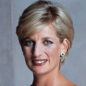 May include: A close-up portrait of a woman with short, blonde hair. She is wearing a simple, elegant outfit and has a warm, friendly smile.