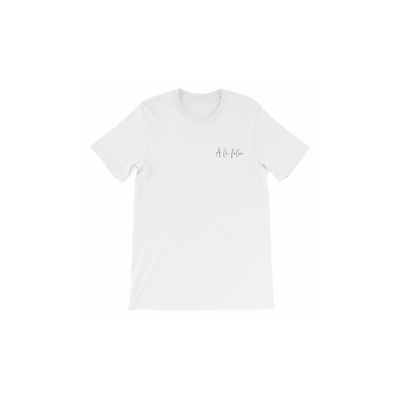 May include: White t-shirt with the text "A la folie" printed on the front.