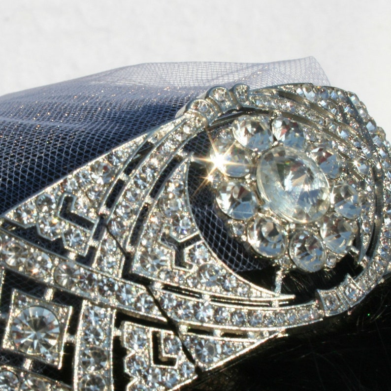 Puede incluir: Un peine para el cabello de plata y cristal con un dise&ntilde;o geom&eacute;trico. El peine est&aacute; adornado con diamantes de imitaci&oacute;n y un gran cristal transparente en el centro.