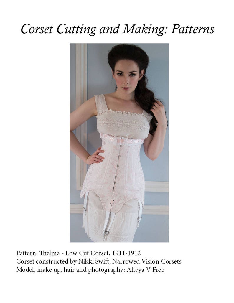 Puede incluir: Un cors&eacute; blanco con un patr&oacute;n floral y un escote bajo. El cors&eacute; lo lleva puesto una modelo con el pelo largo y oscuro. El texto "Pattern: Thelma - Low Cut Corset, 1911-1912" es visible en la parte inferior de la imagen. El texto "Corset constructed by Nikki Swift, Narrowed Vision Corsets" es visible debajo de la primera l&iacute;nea de texto. El texto "Model, make up, hair and photography: Alivya V Free" es visible debajo de la segunda l&iacute;nea de texto.