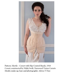 Puede incluir: Un cors&eacute; beige claro con bandas de control de cadera, con un top de encaje y una enagua blanca. El cors&eacute; fue construido por Nikki Swift, Narrowed Vision Corsets. La modelo es Alivya V Free. Patr&oacute;n: Myrtle - Cors&eacute; con bandas de control de cadera, 1918.