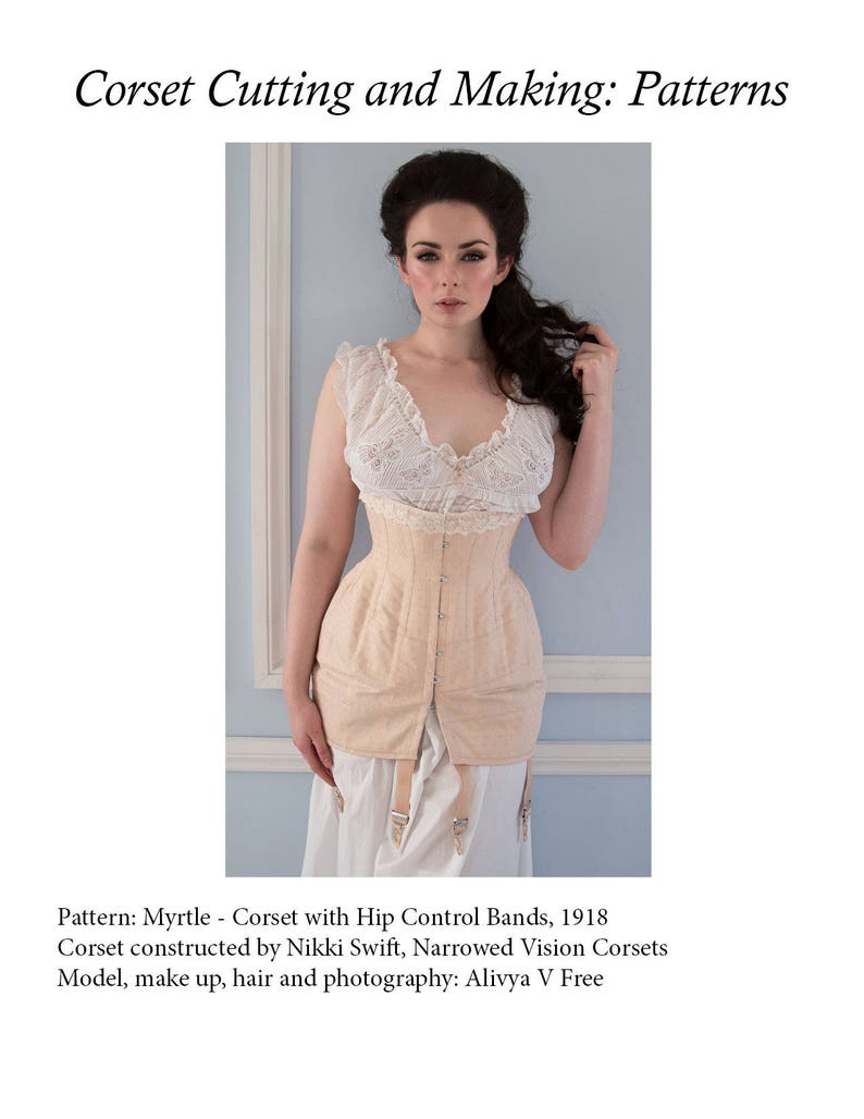Puede incluir: Un cors&eacute; beige claro con bandas de control de cadera, con un top de encaje y una enagua blanca. El cors&eacute; fue construido por Nikki Swift, Narrowed Vision Corsets. La modelo es Alivya V Free. Patr&oacute;n: Myrtle - Cors&eacute; con bandas de control de cadera, 1918.