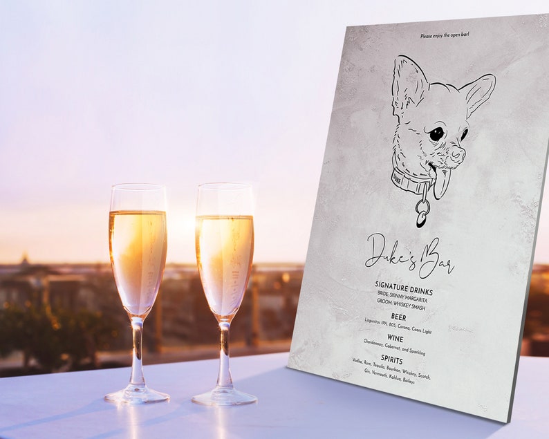 May include: Two champagne flutes filled with a golden liquid stand in front of a sign that reads "Duke's Bar." The sign features a line drawing of a dog and lists signature drinks, beer, wine, and spirits. The background shows a sunset.