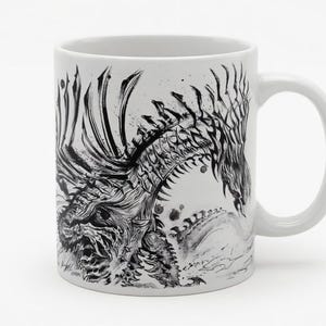 Può includere: Tazza in ceramica bianca con una dettagliata illustrazione in bianco e nero di un drago. L'opera d'arte copre la maggior parte della superficie della tazza, con la forma del drago ben visibile. La tazza ha un manico standard e un design pulito.