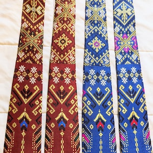 May include: Four patterned neckties in burgundy, maroon, blue, and navy blue with gold and white accents. The ties have a geometric design.
