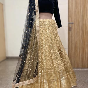 Gold lehenga with black long sleeve blouse embroidered dupatta