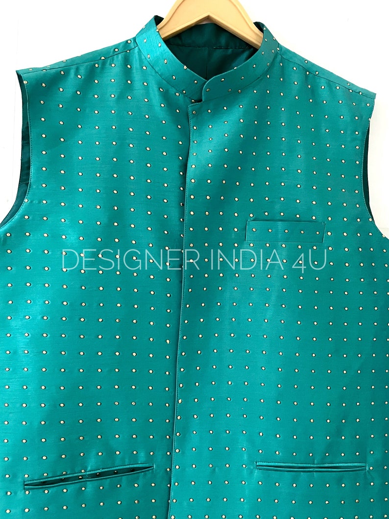 May include: A teal sleeveless vest with a mandarin collar and a white polka dot pattern. The vest has two pockets on the front and the text "DESIGNER INDIA 4U" is visible on the front.
