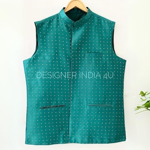 May include: A teal blue sleeveless vest with a mandarin collar and a white polka dot pattern. The vest has two pockets and the text "DESIGNER INDIA 4U" is printed on the front.