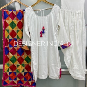 Pu&ograve; includere: Completo salwar kameez bianco con un dupatta ricamato a colori. Il kameez ha una scollatura rotonda e maniche lunghe. Il salwar &egrave; bianco semplice e il dupatta ha un motivo geometrico.