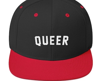 May include: A black and red baseball cap with the word "QUEER" embroidered in white on the front.