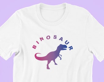 May include: White t-shirt with a pink and blue dinosaur silhouette and the text "BINOSAUR" in a circle around it.