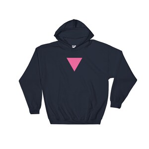 Puede incluir: Una sudadera con capucha azul marino con un tri&aacute;ngulo rosa en la parte delantera.