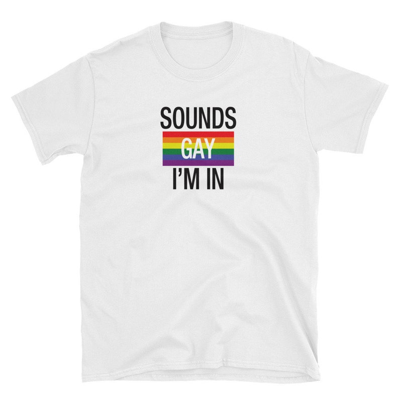 May include: White t-shirt with the text "SOUNDS GAY I'M IN" and a rainbow pride flag.