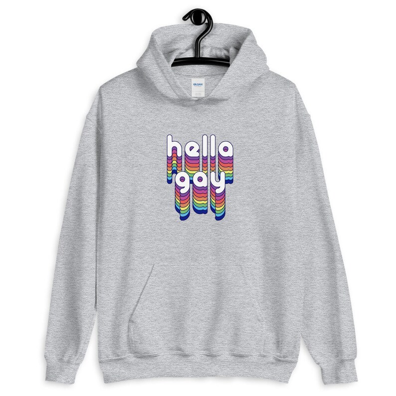 Op de afbeelding: Een grijze hoodie met een regenboogkleurige "hello gay" print op de voorkant.