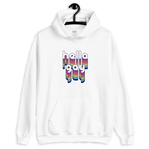 Op de afbeelding: Witte hoodie met een regenboogkleurige "hello gay" print op de voorkant.