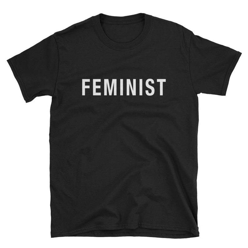 May include: Black short-sleeved t-shirt with the word "FEMINIST" printed in white on the front.