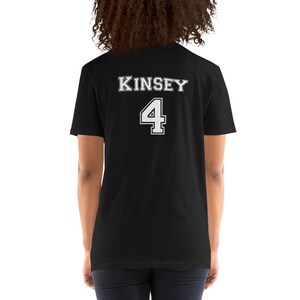 Puede incluir: Camiseta negra con texto blanco que dice "KINSEY 4" en la espalda.