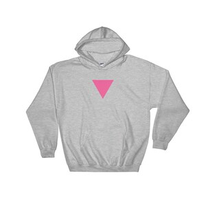 Puede incluir: Una sudadera con capucha gris con un tri&aacute;ngulo rosa en la parte delantera.