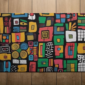 May include: Rectangular black doormat with a vibrant, geometric pattern. The design features colorful squares and rectangles in shades of yellow, red, green, blue, and white. The abstract shapes create a bold, eye-catching design, suitable for a home entrance.