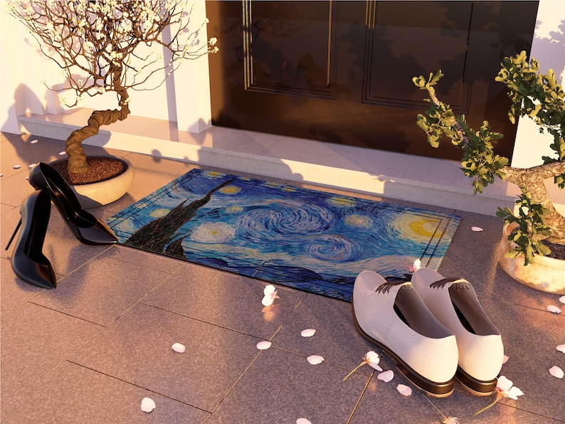 May include: A blue and yellow doormat with a swirling pattern reminiscent of Van Gogh's Starry Night. The doormat is placed on a brown tiled floor with white flower petals scattered around it. Two pairs of shoes are placed on the floor, one pair is black heels and the other pair is white leather shoes.