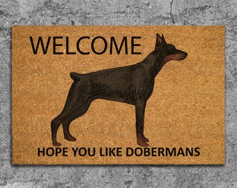 Könnte beinhalten: Willkommen-Fußmatte mit einer braunen und schwarzen Dobermann-Silhouette und dem Text "Welcome" und "Hope you like Dobermans".