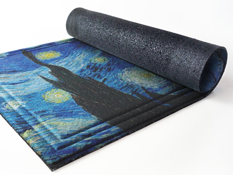 May include: A rolled-up doormat with a blue and yellow starry night design. The doormat has a black backing.