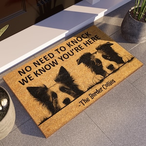 May include: A brown coir doormat with the text "No need to knock we know you're here - The Border Collies" and two black and white border collies peeking over the top.