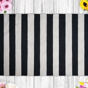a black and white striped rug next to flowers
