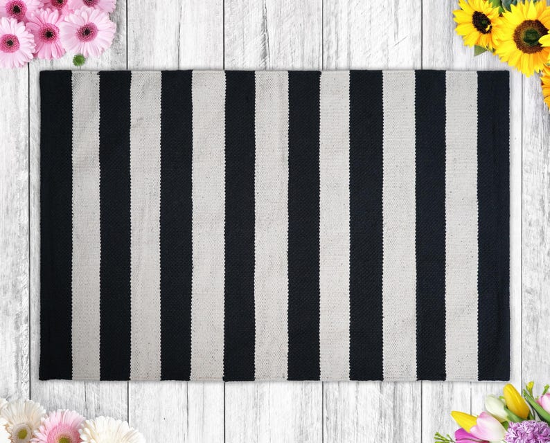 a black and white striped rug next to flowers