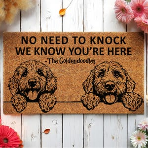 May include: A rectangular doormat with a brown coir surface. The mat features two black line drawings of Goldendoodle dogs and the text "NO NEED TO KNOCK WE KNOW YOU'RE HERE - The Goldendoodles".