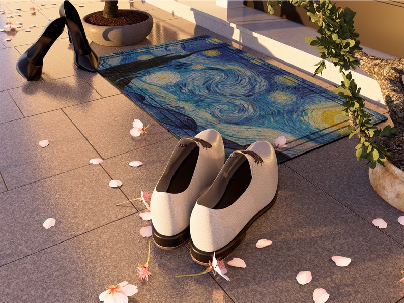 May include: A pair of white leather shoes with black laces sit on a tiled floor with pink flower petals scattered around them. A blue and yellow doormat with a swirling pattern is in the background.