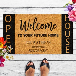 Op de afbeelding: Een bruine kokosmat met zwarte letters die aan de zijkanten "Open House" en in het midden "Welcome to your future home Joe Watshon 555-555-5555 Realtor Agent" staat.
