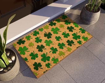 Peut inclure: Un paillasson brun avec un motif de trèfles verts. Le paillasson est en coco et a un aspect naturel et rustique.