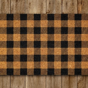 May include: A black and brown checkered doormat made of coir. The doormat has a rustic, farmhouse style.