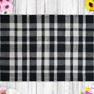 a black and white checkered rug next to flowers
