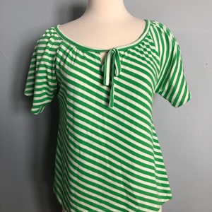May include: Green and white striped short-sleeved shirt with a tie at the neckline.