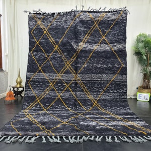 May include: A black and white Moroccan rug with a geometric pattern of yellow diamonds. The rug has a fringe border.