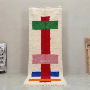 Puede incluir: Una taza de cerámica blanca con un asa negra y el texto "But First, Coffee" en negrita negra. La taza está llena de un líquido oscuro, probablemente café, y se encuentra sobre una superficie clara.