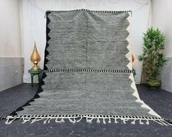 May include: A black and white striped rug with a geometric pattern and fringe. The rug is made of wool and has a soft, textured feel.