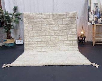 May include: A white, fluffy rug with a brick pattern. The rug is made of wool and has a soft, luxurious feel.