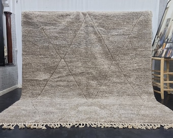 Puede incluir: Una alfombra grande, rectangular, de color marrón claro con un patrón de diamantes. La alfombra tiene un borde de flecos.