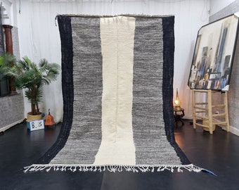 May include: A black and white striped rug with a fringe border. The rug has a long, narrow shape and is made of a soft, textured material.