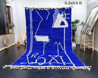 Puede incluir: Una alfombra marroquí azul y blanca con un diseño geométrico. La alfombra mide 1.9x2.9 metros.