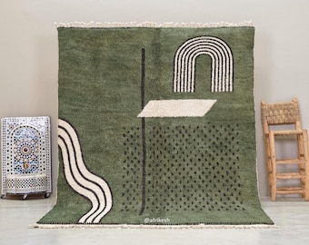 May include: A large, olive green rug with a geometric design. The rug features a black vertical line, a white and black arched shape, and a white angled shape. A wavy white and black design is on the left side. The rug has a fringe at the top and bottom.