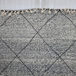 May include: Black and white rug with a diamond pattern. The rug has a fringe border.