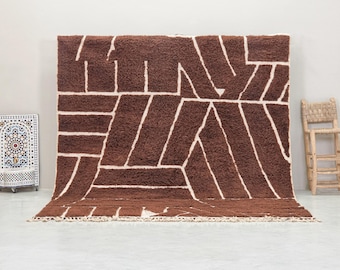 May include: A brown and white geometric patterned rug with a fringe border. The rug has a shaggy texture.
