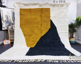 Könnte beinhalten: Ein weißer, gelber und schwarzer geometrischer Teppich mit Fransen. Der Teppich ist 8 Fuß mal 10 Fuß groß.
